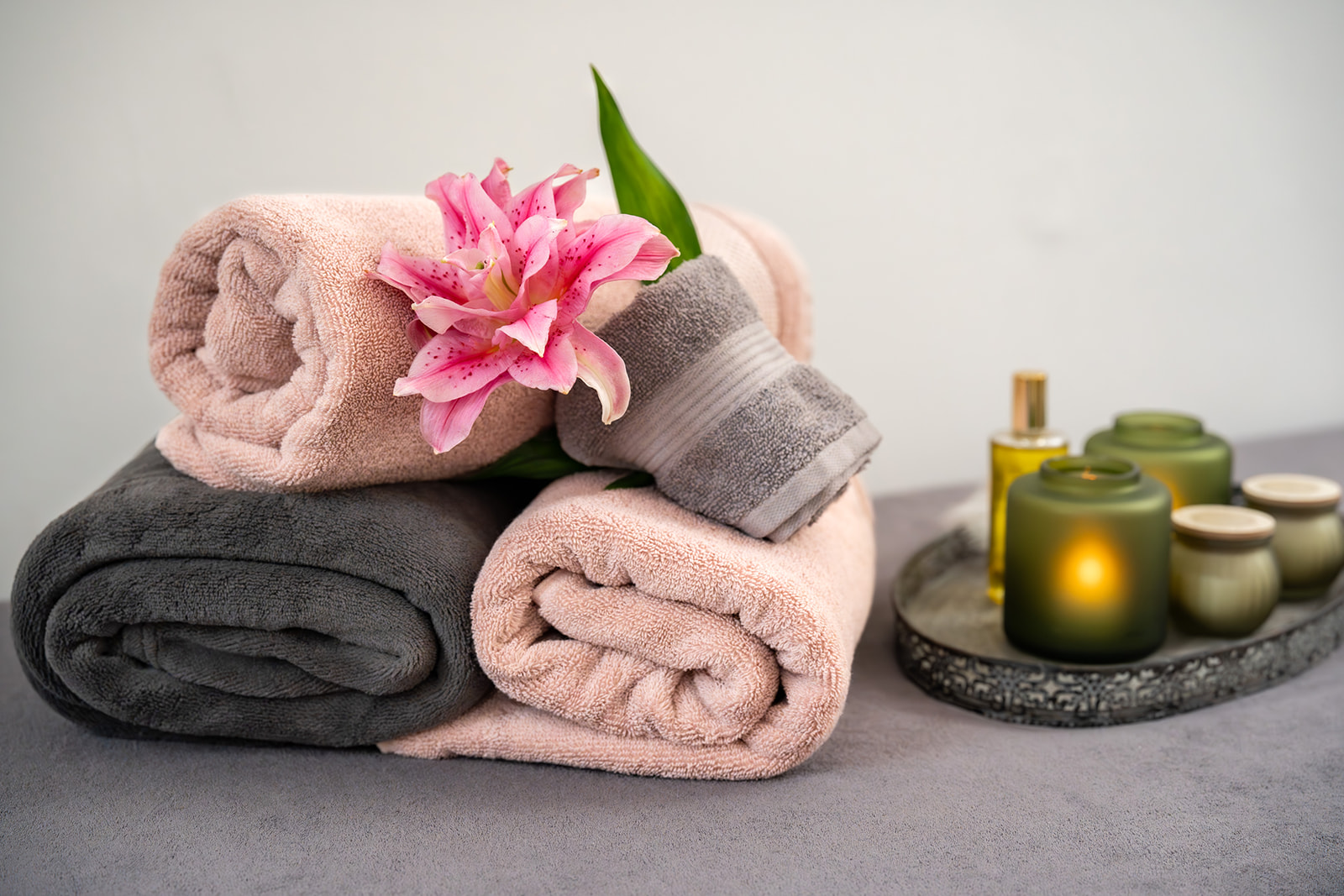 Entspannende Atmosphäre mit Kerzen, Massageöl und Blumen – Symbol für Selbstfürsorge, Ruhe und Achtsamkeit im Coaching von Maren Wolf in Lübeck-St. Jürgen.